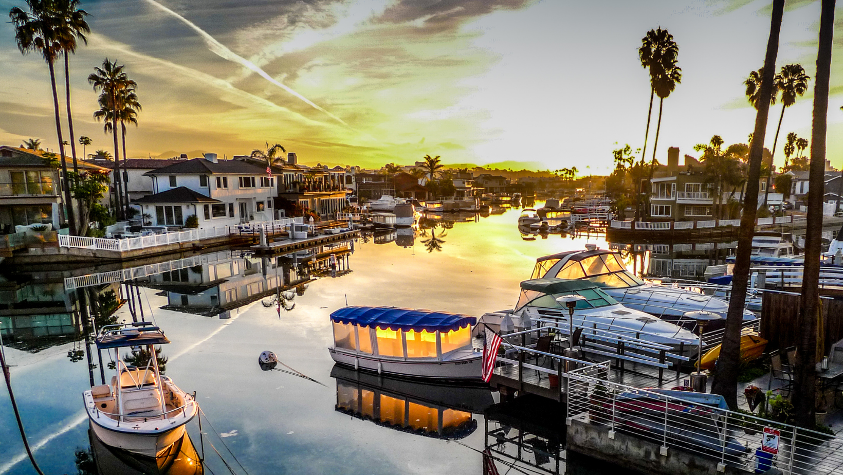 boat launches next to houses in the bay of newport beach