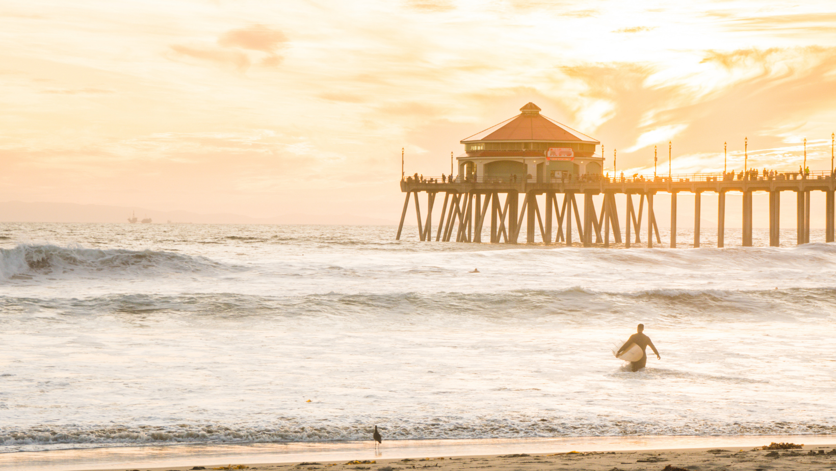 man surfing at huntington beach in the sunset