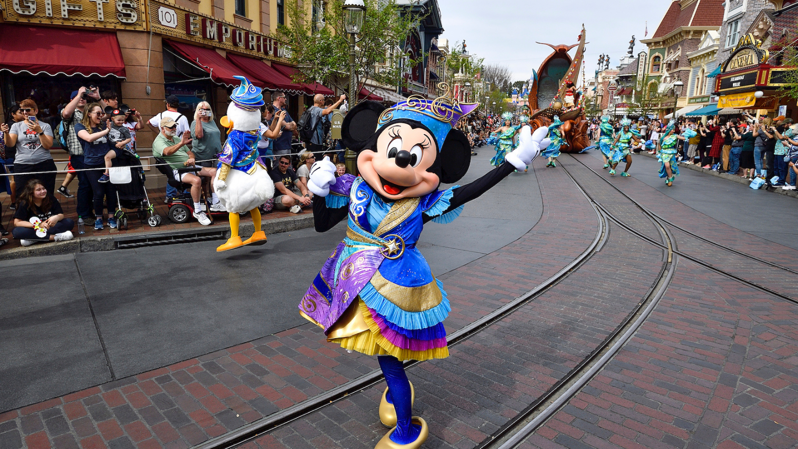 minnie mouse in the middle of a parade on main street